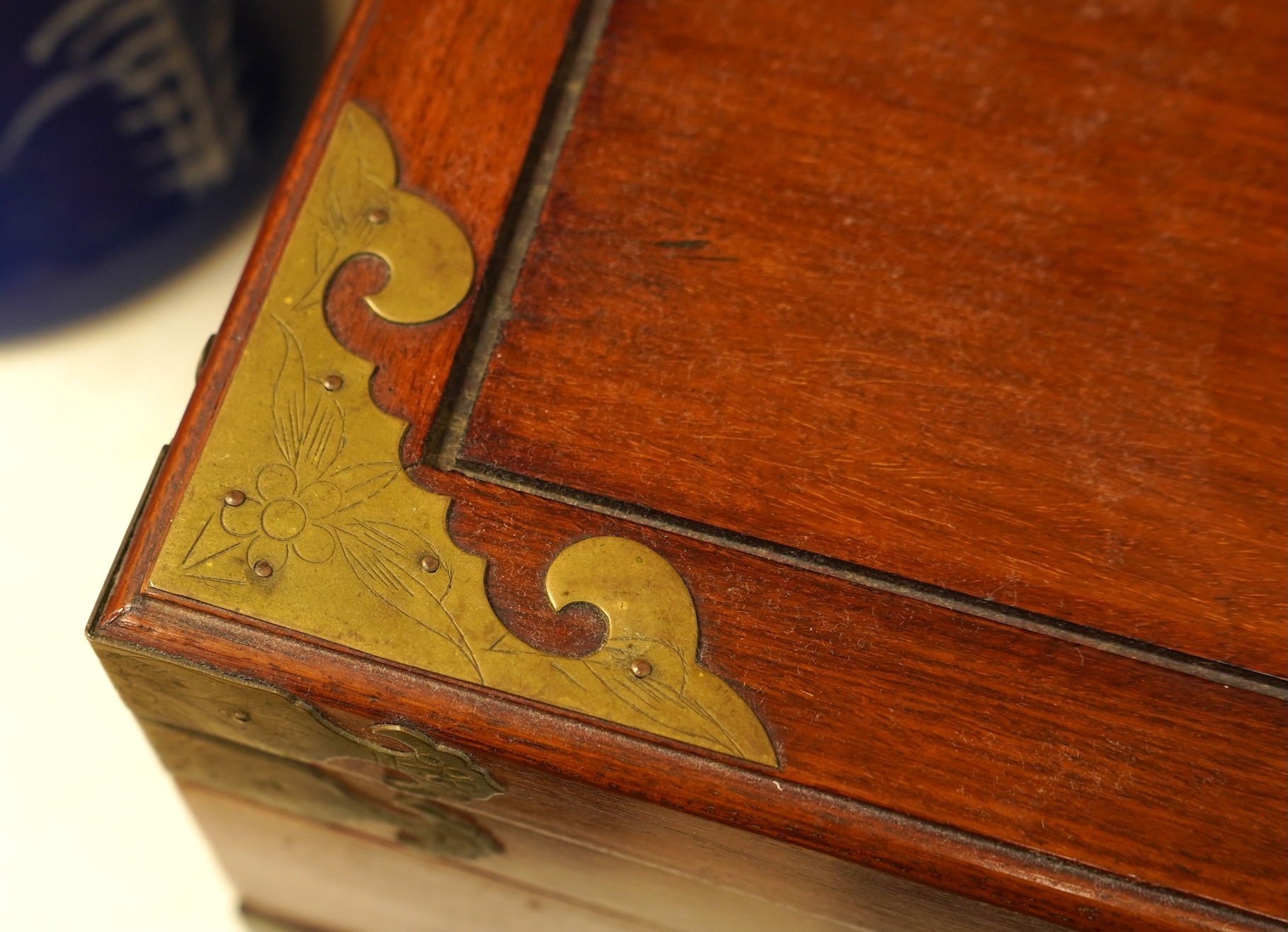 A Chinese brass bound rosewood jewellery box with twin handles, the interior with sewing accessories and threads, 35cm wide